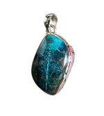 Blue stone pendant with silver setting on a white background