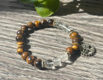 Bracelet with tiger eye and clear quartz beads on a wooden surface