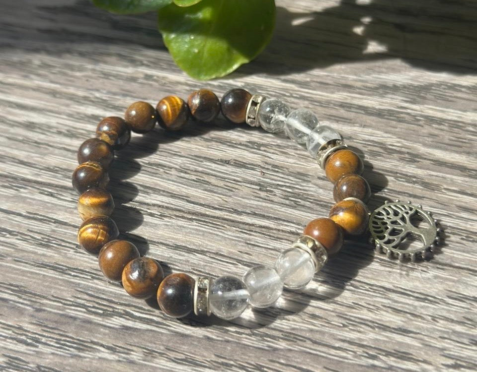 Bracelet with tiger eye and clear quartz beads on a wooden surface